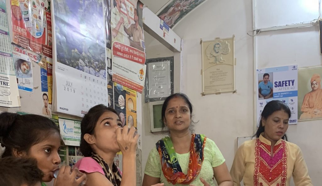 Community health workers administer TB medication to patients at a pop-up community health center in Tekhand Village India