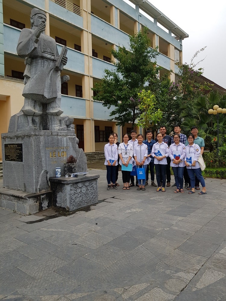 Skilled volunteer, Sam, with the HOCMAI education team standing beside a statue